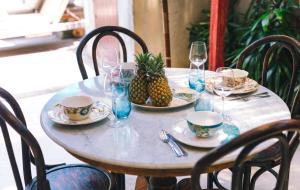 a table with plates and glasses and a pineapple on it at Villa Vickary Seminyak in Seminyak