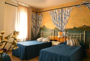 プリエゴ・デ・コルドバにあるHotel Las Rosasのベッドルーム1室(ベッド2台付)が備わります。壁には絵画が飾られています。
