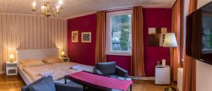 een slaapkamer met een bed, een stoel en een raam bij Pension Menge in Bad Schandau