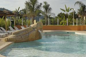 a swimming pool with a waterfall in a resort at Hotel Lou Castelet in Carros