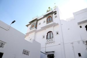 a white building with windows on the side of it at Little Garden Guest House in Udaipur