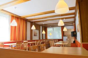 a dining room with tables and chairs and lights at Jugendgästehaus Bad Ischl in Bad Ischl