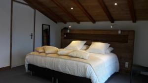 a bedroom with a large bed with white sheets and pillows at Hotel L'alpin in Landry