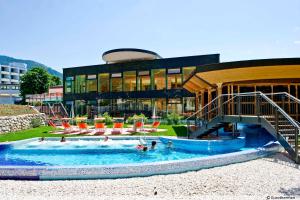 a pool in front of a building with people in it at Jugendgästehaus Bad Ischl in Bad Ischl