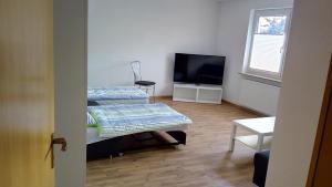 フィルダーシュタットにあるKomfort Apartment 2 EG bei Jürgen Kunziのベッド2台、薄型テレビが備わる客室です。