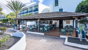 
a patio area with chairs, tables and umbrellas at Blue Sea Costa Bastian in Costa Teguise

