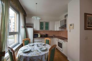 a kitchen with a table with chairs and a window at Central Apartment Anita Tour As Ljubljana in Ljubljana