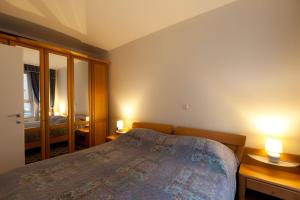 1 dormitorio con 1 cama, 2 mesas y 2 lámparas en Central Apartment Anita Tour As Ljubljana, en Liubliana