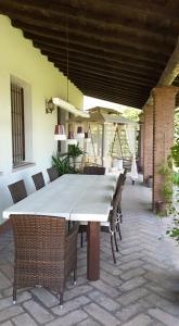 - une table et des chaises blanches sur la terrasse dans l'établissement B&B Nascondino, à Goito