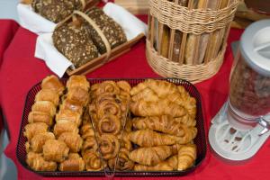 a table with a tray of pastries and baskets of bread at Thalacap Île de Ré - Thalasso & Spa in Ars-en-Ré