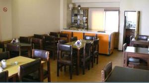 a restaurant with wooden tables and chairs and a counter at Hotel City in Trelew