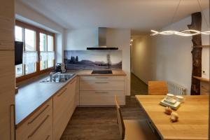 a kitchen with a sink and a wooden table at Das Apartment Rief daheim beim Wanderprofi Adults Only in Tannheim