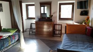 a living room with a bed and a dresser with a mirror at Cascina Rosa Camilla in Carpeneto