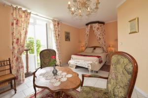 sypialnia z łóżkiem, stołem i krzesłami w obiekcie Aurore de Beaufort w mieście Saint-Martin-le-Beau