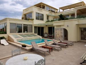 a large house with a swimming pool and chairs at Maison d'Hôtes Dar Ennassim in La Marsa