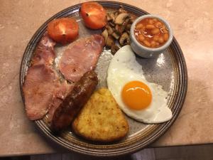 un plato de desayuno con huevos tocino y judías en Carinya en Talgarth