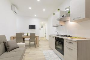 een keuken en een woonkamer met een bank en een tafel bij Dreaming Taormina Apartment in Taormina