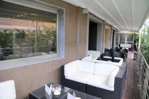 a patio with white chairs and tables on a balcony at Hotel Carla in Levanto