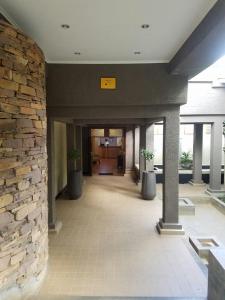 a lobby with a stone wall and two potted plants at Ufulu Gardens Hotel in Lilongwe