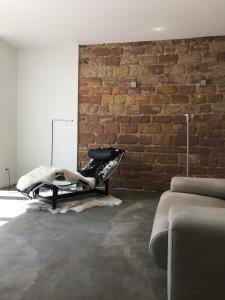 a black chair in a room with a brick wall at pirrung lebensräume in Sankt Ingbert