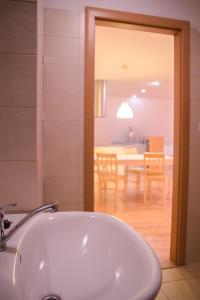 a bathroom with a white sink and a dining room at Old Town Apartment in Trenčín