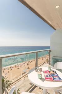 a balcony with a table and a view of a beach at Pierre & Vacances Blanes Playa in Blanes
