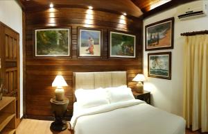 バコロドにあるStay Amare Villa Maria 1のベッドルーム1室(ベッド1台付)が備わります。壁には絵画が飾られています。