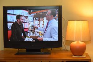 a television sitting on a wooden table with a lamp at Teign Head Apartment in Newton Abbot