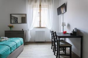 a bedroom with a table and a bed and a desk at Il Filo di Arianna in Bologna
