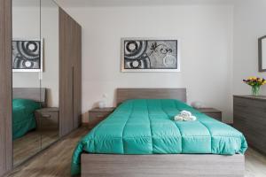 a bedroom with a green bed and a mirror at Il Filo di Arianna in Bologna