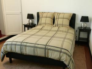 a bedroom with a bed with two tables with lamps at Le Clos Chez Michel in Montpellier