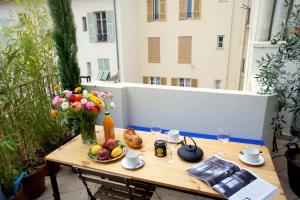 ニースにあるZe Perfect Place - Élégant appartement avec terrasse - Promenade des Artsのバルコニーに飾られたテーブル(フルーツ、花付)