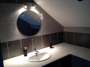 een badkamer met een wastafel en een spiegel bij La Marelle in Avrillé-les-Ponceaux