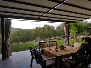 a patio with a table and chairs and a large window at Paomà trentova in Agropoli