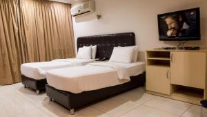 アンマンにあるアフハディア ホテルのベッド2台、薄型テレビが備わるホテルルームです。