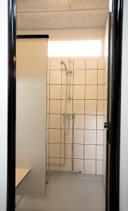 La salle de bains est pourvue d'une douche avec une porte en verre. dans l'établissement Nivå Camping & Cottages, à Nivå