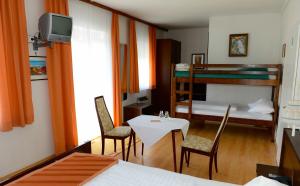 een kamer met een tafel en stoelen en een stapelbed bij Strandhotel Pichler in Seeboden +37 foto's
