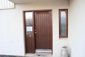 a brown door on the side of a house at Skammidalur Guesthouse in Vík +44 photos