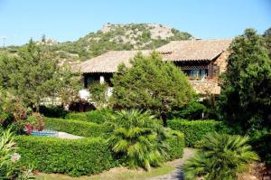 una casa con un jardín con árboles y arbustos en Rotondo Residence - Simar Vacanze, en Porto Rotondo