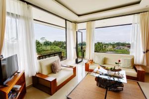 a living room filled with furniture and a large window at Om Ham Retreat and Resort in Ubud