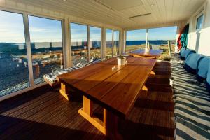 a large wooden table in a room with windows at Haraldshaugen Camping in Haugesund
