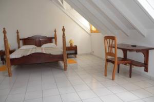 a bedroom with a bed and a table and a chair at Maison Duplex "Josué" vue sur Marina in Grand-Bourg