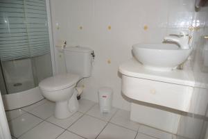 y baño con aseo, lavabo y ducha. en Maison Duplex "Josué" vue sur Marina, en Grand-Bourg