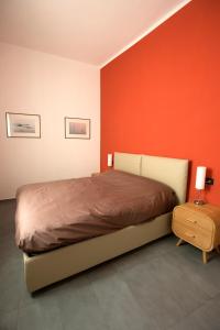 sypialnia z łóżkiem i czerwoną ścianą w obiekcie The Nest w Bolonii