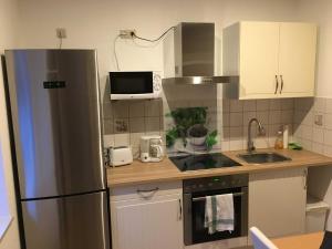 a kitchen with a stainless steel refrigerator and a microwave at Ferienwohnung Sporn in Hemfurth-Edersee