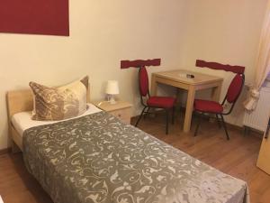 a bedroom with a bed and a table and chairs at Pension am Radweg & Ristorante Juani in Wriezen
