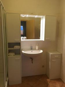 a bathroom with a sink and a mirror at Pension am Radweg & Ristorante Juani in Wriezen +35 photos