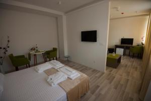 a bedroom with a bed and a table and a television at Hotel Village in Ohrid
