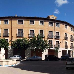 un gran edificio de ladrillo con coches aparcados en un aparcamiento en LaFonda1-2-B, en Borja