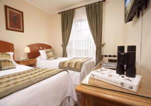 a hotel room with two beds and a window at Hotel Carpa Manzano in Punta Arenas